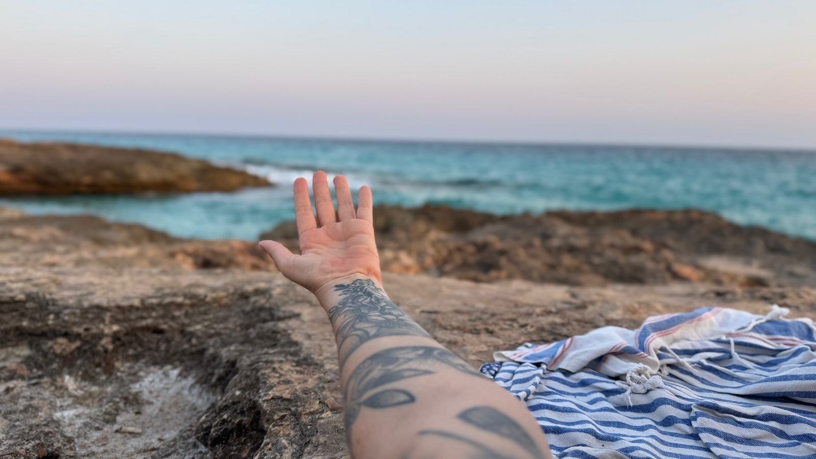 Mano de Julieta extendida frente al mar en Mallorca