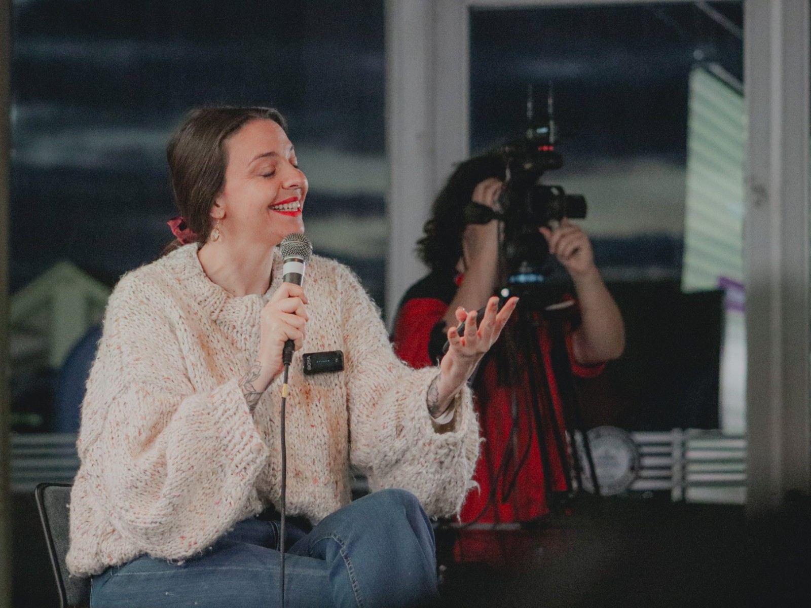 Julieta sonriendo con el micrófono durante una charla