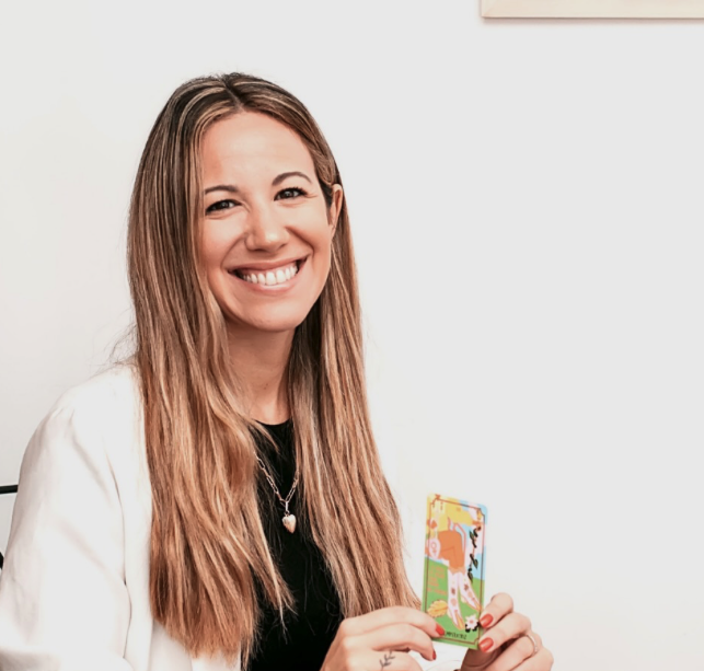 Dani, tarotista y creadora de La Brújula, sosteniendo una carta de tarot